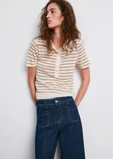Jeans de denim azul oscuro con diseño wide leg, tiro alto, bolsillos de parche delanteros y cierre frontal de cremallera y botón.