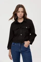 Campera negra de efecto gamuzado con cuello camisero, cierre frontal de botones, bolsillos plaqué en el pecho y detalles de costuras decorativas y calados.