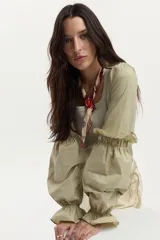Blusa de rib y popelina color verde militar, con escote cuadrado, calce al cuerpo y mangas largas voluminosas con puños fruncidos y volados.