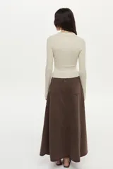Falda larga de denim marrón, de corte evasé con paneles tipo godet y bordado floral en el lateral.
