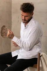 Camisa celeste de manga larga con cuello clásico y cierre frontal con botones.