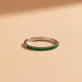 Anillo tipo alianza de oro blanco 18k con engaste de esmeraldas pequeñas en todo el frente.
