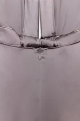 Vestido largo de satén color malva o gris topo, con cuello halter anudado en la espalda y escote pronunciado en V. Presenta frunces centrales en el busto que generan caída y pliegues verticales en la falda.
