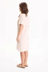 Vestido corto de lino color negro, con escote en V, manga corta y bolsillos laterales, destacado por costuras a contratono en color blanco.