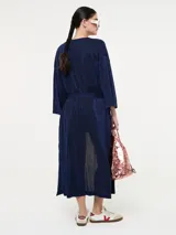 Saco largo azul marino con fajín, de jersey de lúrex con aberturas laterales, mangas largas y bolsillos laterales en costura.