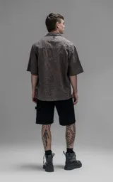 Camisa de manga corta con calce oversize y cuello abierto, confeccionada en algodón con diseño de bordado tipo broderie y efecto de desgaste en el color.