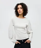 Blusa de algodón color beige con cuello redondo y mangas largas amplias de corte holgado. Presenta un diseño minimalista con costuras sutiles y ajuste regular al cuerpo.
