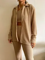 Camisa de tejido tipo waffle color arena, con diseño abierto, mangas largas y corte holgado.