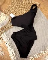 Trikini negro asimétrico con un solo hombro, abertura lateral y corte en la cintura.