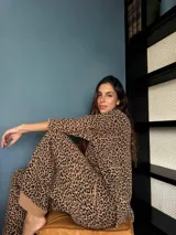 Conjunto de dos piezas tejido con estampado animal print, compuesto por un buzo de silueta oversize con cuello a la base y mangas 3/4, y un pantalón de corte holgado a juego.