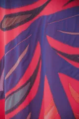 Vestido largo color coral con estampado de hojas en tonos violeta y marrón.