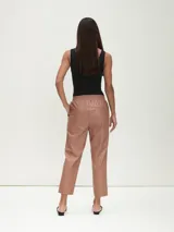 Pantalón negro de cuero sintético con cintura elástica y corte recto.