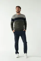 Sweater de punto con cuello redondo, manga larga y diseño a rayas horizontales en tonos gris, azul marino y verde oliva. Logo bordado en el pecho.