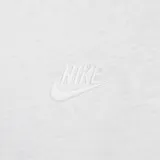Remera Nike de corte holgado, color blanco, con cuello redondo y logo de la marca bordado en el centro del pecho. Presenta una etiqueta pequeña con el logo en el ruedo inferior.