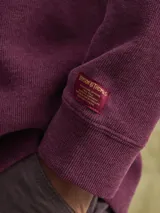 Buzo de cuello redondo confeccionado en tejido fleece, de corte clásico y manga larga, con puños y ruedo acanalados.