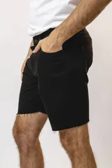 Bermuda de corte recto y estilo casual, confeccionada en tela de jean color negro con terminación deshilachada en el ruedo.