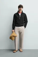 Sudadera polo de corte regular, confeccionada en tejido técnico interlock de algodón con elasticidad. Presenta cuello solapa, cierre frontal de cremallera y manga larga con puños acabados en rib.