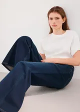 Jeans de denim azul oscuro con corte wide leg, tiro medio y botamanga ancha.