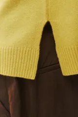 Sweater de tejido de punto verde, con calce regular levemente suelto, escote redondo y mangas largas con puños acanalados.