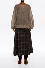 Falda midi de corte línea A, confeccionada en mezcla de lana con estampado de cuadros en tonos verde oscuro, rojo y beige. Presenta cierre lateral oculto, costuras diagonales abiertas y acabados sin rematar en el dobladillo.