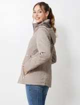 Campera de abrigo color marrón, con diseño capitoneado de costuras entrelazadas en relieve. Presenta cuello alto, capucha desmontable, cierre frontal completo y bolsillos laterales con cierre. Incluye trabas ajustables en la cintura con botones metálicos para entallar la silueta.