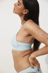 Top de bikini con estampado a rayas azules y blancas, breteles ajustables y copas con relleno push-up. Cierre de gancho en la espalda.