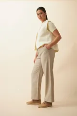 Chaleco color beige con textura tipo espiga, corte holgado y solapa cruzada.