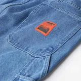 Pantalón de jean azul de corte holgado y estilo carpintero, con costuras reforzadas y bolsillos laterales.