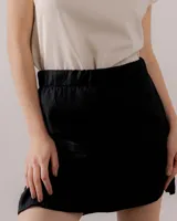 Minifalda negra de lino con cintura elástica y diseño recto.