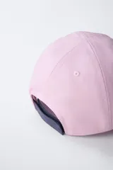 Gorra de béisbol azul marino con visera curva y detalle de borde en color crema. Presenta un bordado frontal con la palabra 'LONDON' en tipografía estilo varsity y texto adicional debajo.