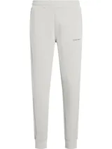 Pantalón de jogging Calvin Klein, confeccionado en mezcla de algodón y fibra Repreve. Presenta cintura elástica, bolsillos laterales, puños ajustados en los tobillos y el logo de la marca estampado en contraste en la pierna izquierda.