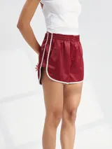 Short deportivo de satén color bordó con cintura elástica y ribetes blancos en los bordes.