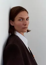 Abrigo largo de corte recto confeccionado en tejido de lana. Presenta cuello en pico, cierre frontal con botones, mangas largas y dos bolsillos laterales. Incluye forro interior.