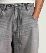 Bermuda de jean para hombre, modelo super baggy, con lavado dirty, bolsillos laterales y cinturón de lazo en la cintura.