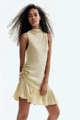 Vestido corto sin mangas en crepé de viscosa, color amarillo, con escote drapeado, costura en la cintura, cierre oculto lateral y volado amplio en el bajo.