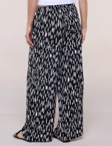 Pantalón de poliéster de corte ancho tipo palazzo y calce relajado, con estampado de hojas en tonos azules, cintura alta elastizada con cordón ajustable y bolsillos laterales.
