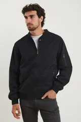 Campera estilo bomber color verde oscuro, con cierre metálico, dos bolsillos externos con cierre y un bolsillo interno.