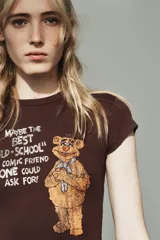 Camiseta slim fit de manga corta y cuello redondo, color marrón, con estampado frontal de Fozzie Bear de The Muppets y la frase "Maybe the best 'old-school' comic friend anyone could ask for!".