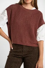 Chaleco sin mangas de tejido de punto color rosado pálido, con textura calada y acabado lurex, corte al cuerpo y cuello redondo.