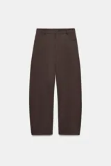 Pantalón de tiro alto con diseño tipo balloon, cintura con trabillas, bolsillos laterales y cierre frontal con cremallera y botón.