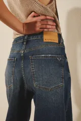 Jean de corte oxford y tiro medio, confeccionado en denim de color azul clásico. Presenta un diseño de pierna ancha y holgada, con cierre frontal y bolsillos laterales y traseros.