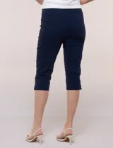 Pantalón capri blanco de tiro alto, corte entallado y silueta ajustada, con pretina ancha elastizada sin cierres, bolsillos simulados al frente y pequeños tajos en los ruedos.