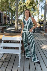 Pantalón tejido de corte recto y tiro alto, con diseño de rayas verticales onduladas en colores beige y negro. Presenta una cintura elástica con cordón ajustable.