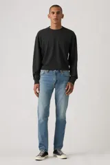 Jean de corte slim fit, color celeste, con cierre de cremallera y botón metálico. Presenta un diseño clásico de cinco bolsillos con costuras reforzadas.