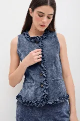 Chaleco de terciopelo azul marino con efecto desgastado, presenta volados decorativos a lo largo del cierre frontal y en la cintura, con cuello alto y diseño ajustado.