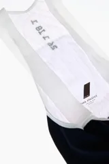 Short de ciclismo con tirantes, color blanco, de tejido elástico y diseño ergonómico con badana y detalles gráficos en negro.