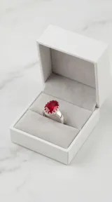 Anillo de plata 925 con diseño ovalado y piedra central de circonia en color rojo.