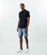 Remera polo de corte comfort, confeccionada en algodón peruano de alta calidad. Presenta cuello clásico con tapeta de botones y mangas cortas. Diseño liso y texturizado, ideal para un look casual y fresco.