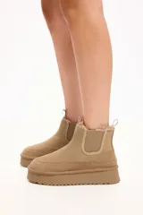 Bota tipo chelsea de gamuza color camel, con interior forrado en piel sintética, elásticos laterales y plataforma alta con suela dentada.