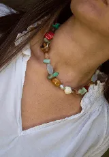 Gargantilla corta de piedras naturales multicolor, con cuentas de diferentes formas, tamaños y tonos como turquesa, marrón, blanco, rojo y celeste.